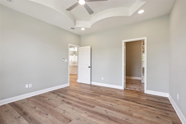 unfurnished bedroom featuring light hardwood / wood-style floors, a spacious closet, and ceiling fan