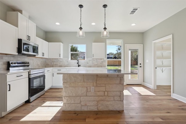 109 Creekside Dr, Bastrop, TX 78602 - kitchen featuring stainless steel appliances, a sink, backsplash, light wood-type flooring, and light countertops
