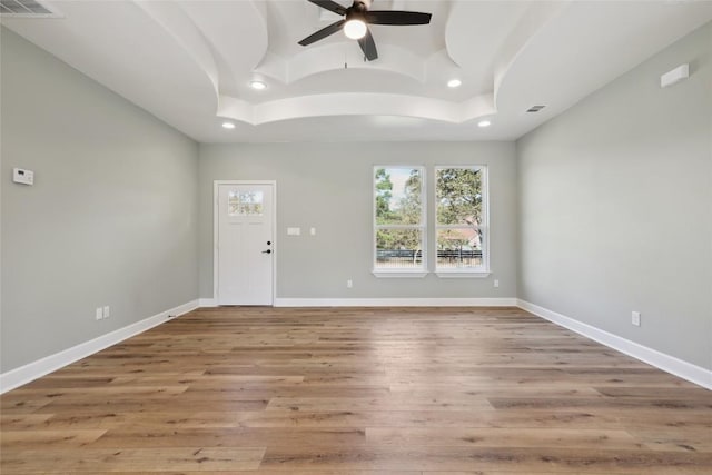 109 Creekside Dr, Bastrop, TX 78602 - spare room featuring a raised ceiling, ceiling fan, healthy amount of natural light, recessed lighting, and wood finished floors