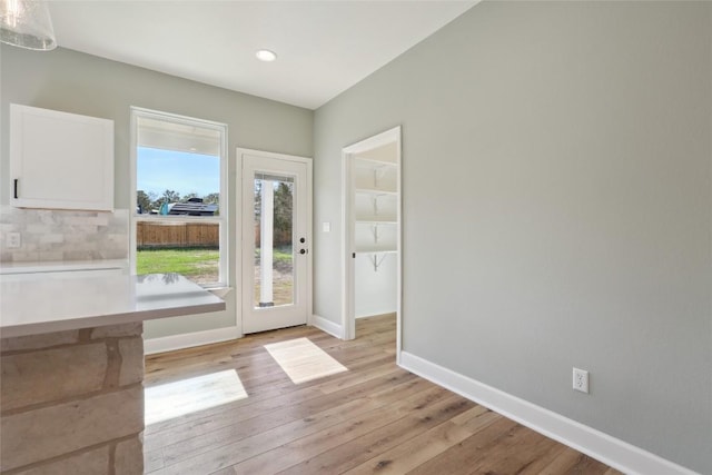 doorway with light hardwood / wood-style floors and a wealth of natural light