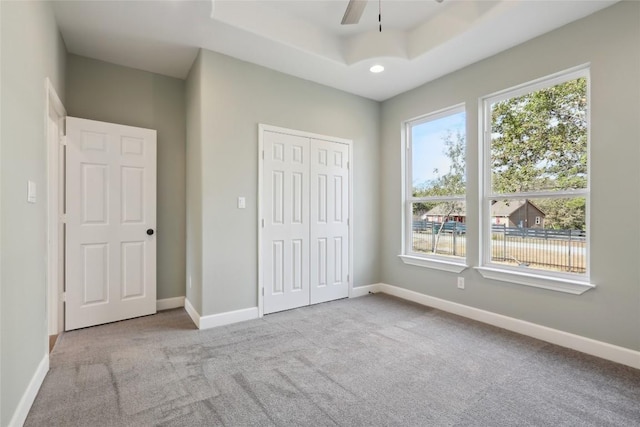 109 Creekside Dr, Bastrop, TX 78602 - unfurnished bedroom featuring carpet floors, a closet, baseboards, a tray ceiling, and recessed lighting