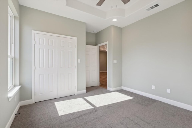 109 Creekside Dr, Bastrop, TX 78602 - unfurnished bedroom with carpet floors, a closet, a tray ceiling, baseboards, and recessed lighting