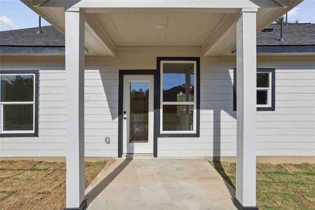 109 Creekside Dr, Bastrop, TX 78602 - doorway to property with roof with shingles, a patio area, and a lawn