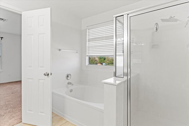 bathroom with tile patterned floors and shower with separate bathtub