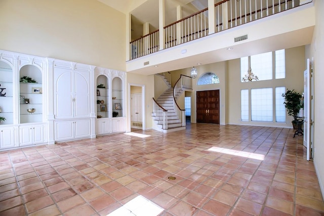 tiled foyer with a high ceiling and a notable chandelier