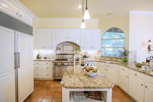 kitchen with decorative backsplash, pendant lighting, premium appliances, and white cabinetry