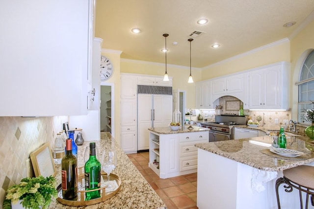 kitchen with light stone countertops, ornamental molding, white cabinetry, and high quality appliances