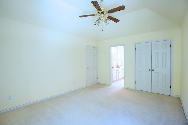 unfurnished bedroom with ceiling fan, a closet, light carpet, and lofted ceiling