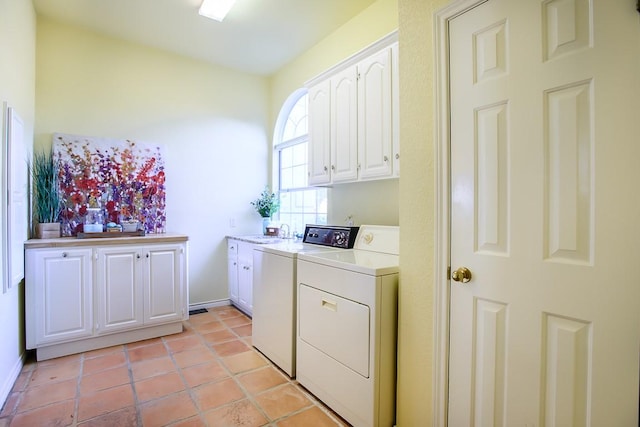 laundry room with light tile patterned floors, cabinets, and independent washer and dryer