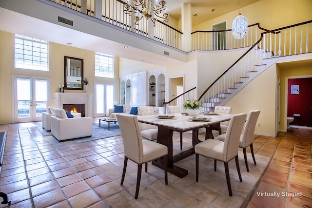 dining area featuring tile patterned flooring, a high ceiling, french doors, and plenty of natural light