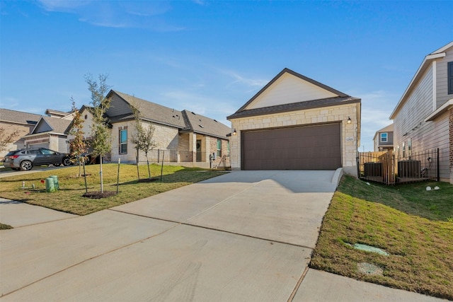 single story home with a front yard, central AC, and a garage