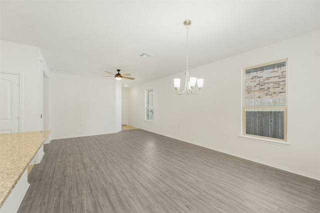12521 Orchard Grove Ln, Manor, TX 78653 - unfurnished living room with light wood-style floors, a ceiling fan, a chandelier, and baseboards