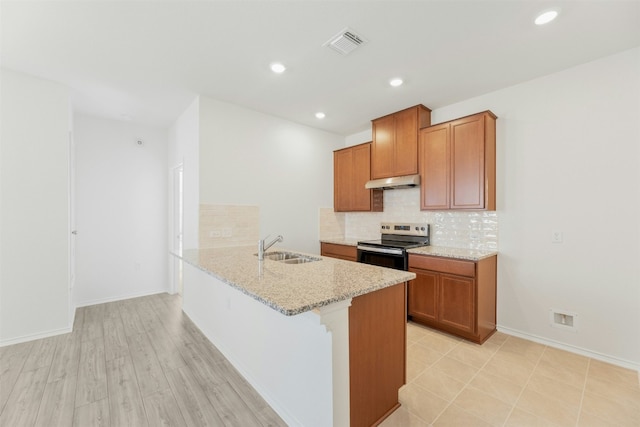 kitchen with electric stove, sink, decorative backsplash, light stone countertops, and light hardwood / wood-style floors