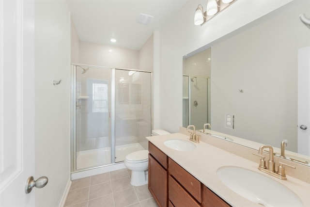 bathroom with tile patterned flooring, vanity, a shower with door, and toilet