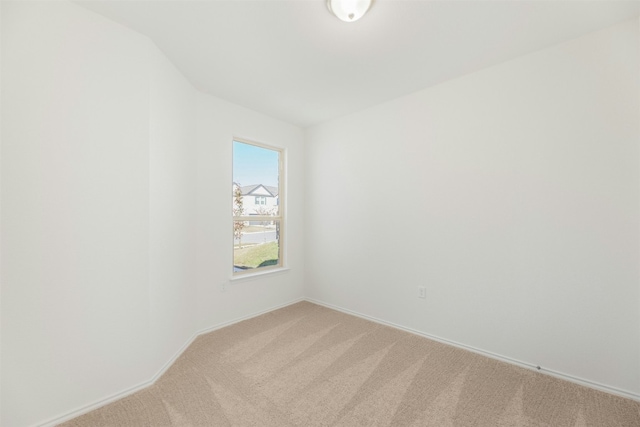 carpeted spare room featuring lofted ceiling