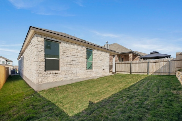 12521 Orchard Grove Ln, Manor, TX 78653 - back of house featuring a gazebo, stone siding, and central AC