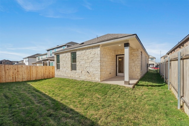 12521 Orchard Grove Ln, Manor, TX 78653 - rear view of property featuring stone siding, a patio area, and a shingled roof