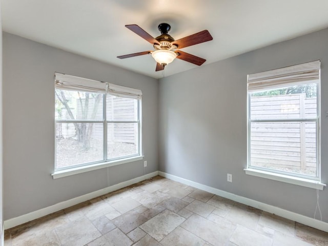 unfurnished room with ceiling fan and a wealth of natural light