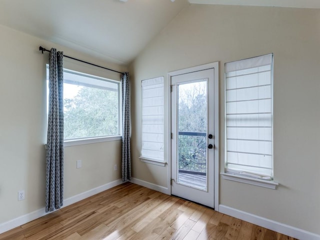 entryway featuring plenty of natural light, lofted ceiling, and light hardwood / wood-style flooring