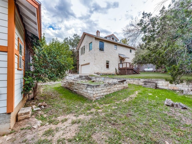 rear view of property with a garage and a yard