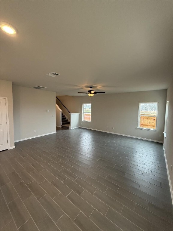 unfurnished living room with ceiling fan and dark hardwood / wood-style floors