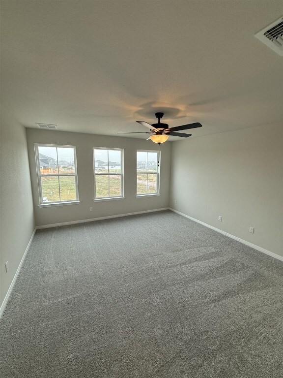 carpeted empty room featuring ceiling fan