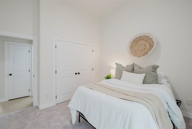 bedroom featuring light carpet and a closet