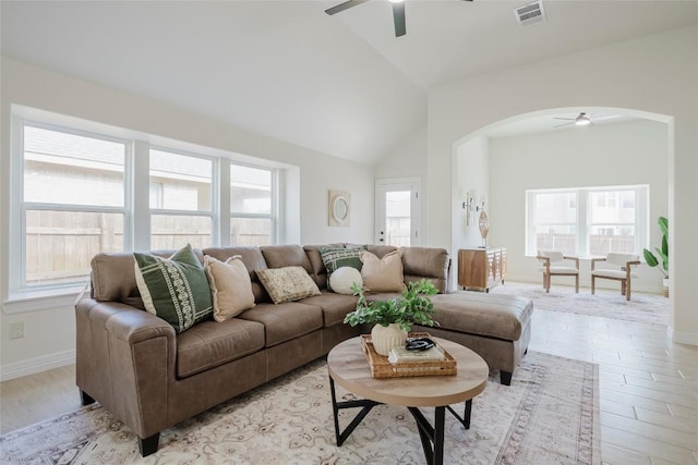 living room with ceiling fan, high vaulted ceiling, and light wood-type flooring