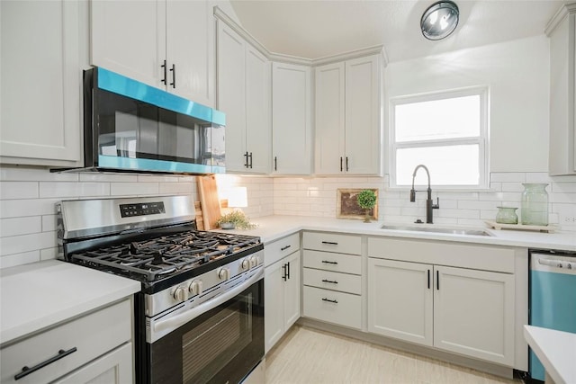 kitchen with decorative backsplash, sink, white cabinets, and stainless steel appliances