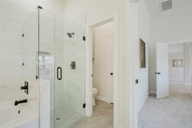 bathroom featuring tile patterned flooring, toilet, and an enclosed shower