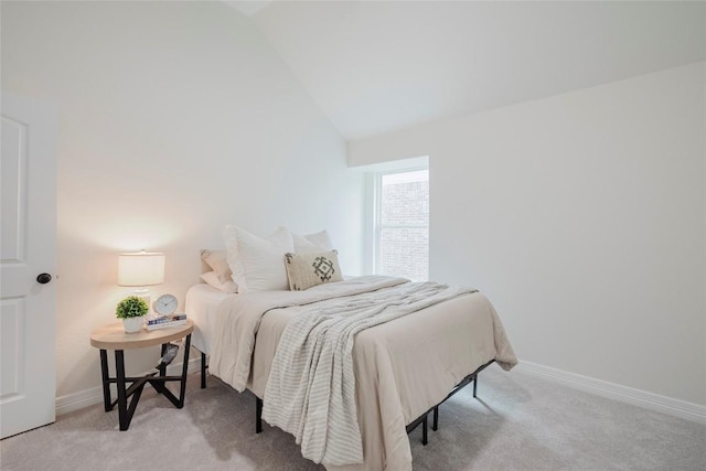 bedroom featuring lofted ceiling and light carpet