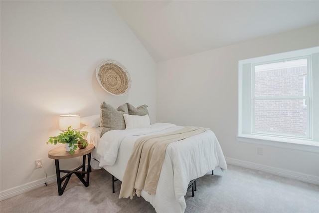 carpeted bedroom featuring lofted ceiling and multiple windows