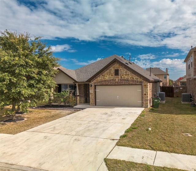 view of front of home featuring cooling unit, a garage, and a front lawn