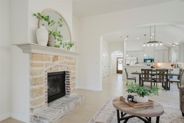 living room with a stone fireplace and sink