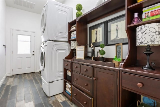 laundry area with stacked washer and dryer and dark hardwood / wood-style floors