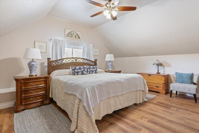 bedroom featuring ceiling fan, hardwood / wood-style floors, and vaulted ceiling