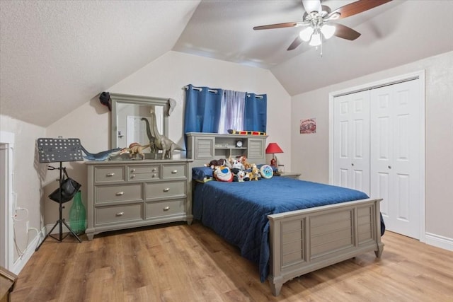 bedroom featuring a closet, ceiling fan, light hardwood / wood-style flooring, and lofted ceiling