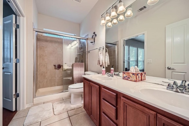 bathroom with tile patterned floors, toilet, vanity, and walk in shower