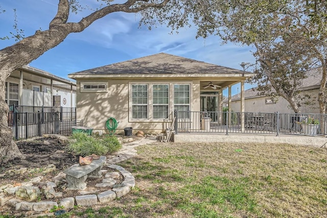 rear view of property with a yard and ceiling fan