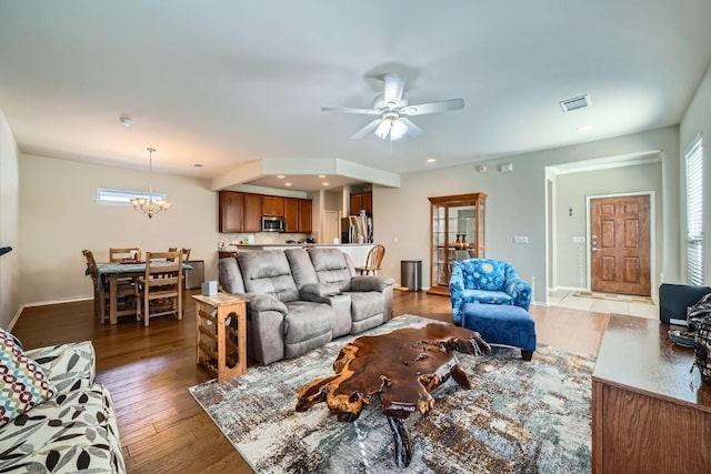 living room with hardwood / wood-style floors, ceiling fan with notable chandelier, and a healthy amount of sunlight