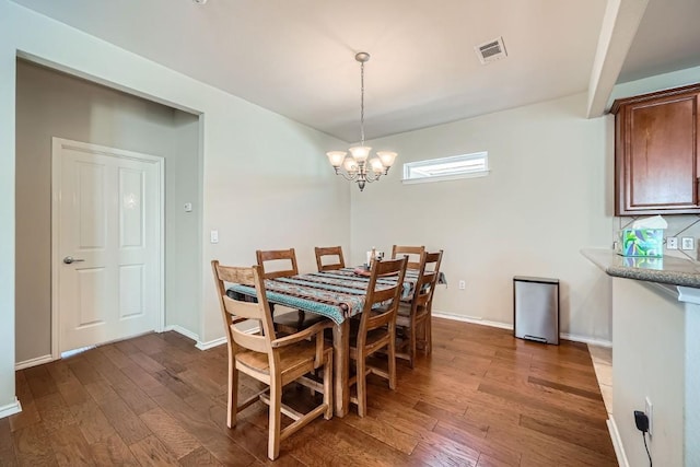 dining room featuring dark hardwood / wood-style floors and an inviting chandelier