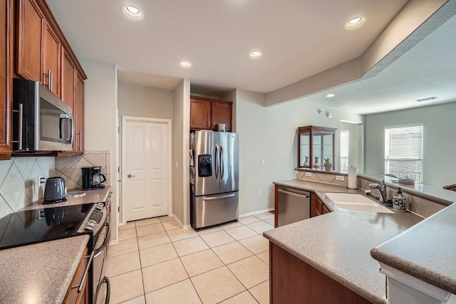 kitchen with tasteful backsplash, sink, light tile patterned floors, and stainless steel appliances