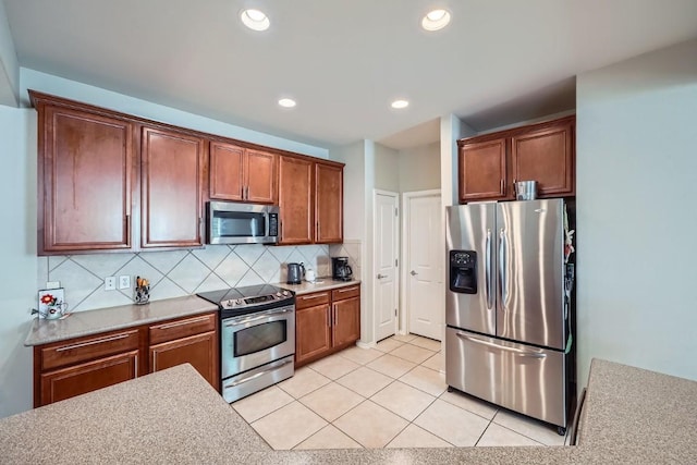 kitchen featuring decorative backsplash, light tile patterned floors, and stainless steel appliances