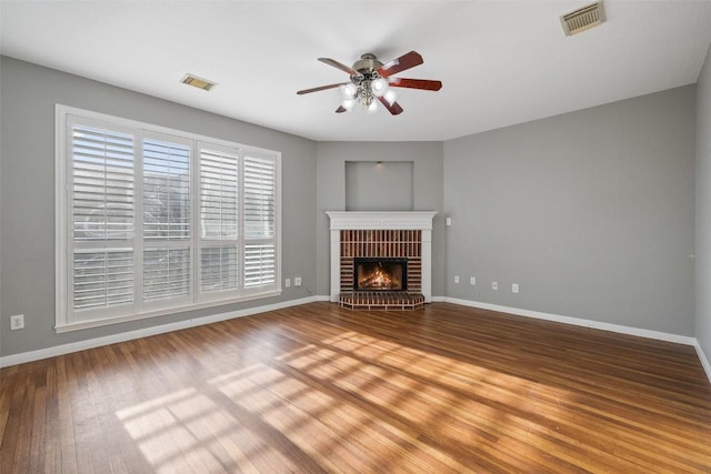 unfurnished living room with a fireplace, hardwood / wood-style flooring, and ceiling fan