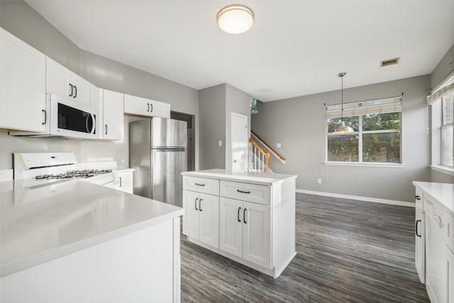 kitchen with pendant lighting, white cabinetry, white appliances, and dark wood-type flooring