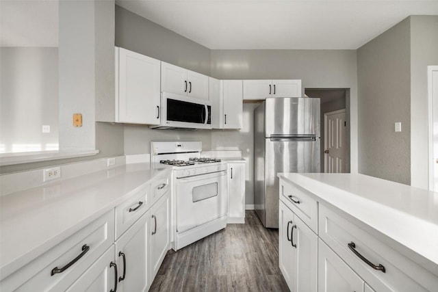 kitchen with white appliances, dark hardwood / wood-style floors, and white cabinets