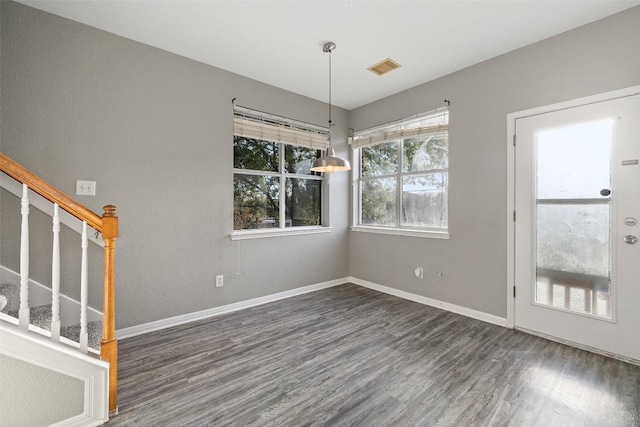 unfurnished dining area with dark wood-type flooring