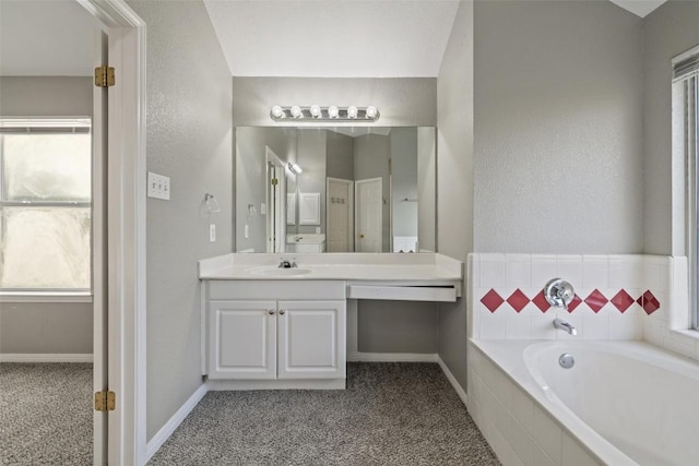 bathroom featuring vanity and tiled tub