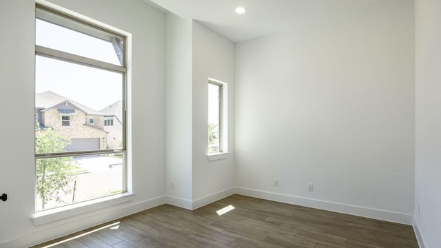 empty room featuring recessed lighting, wood finished floors, and baseboards