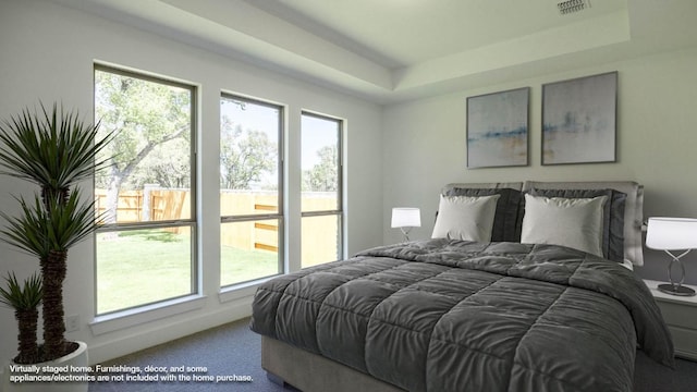 bedroom with carpet floors, a raised ceiling, visible vents, and multiple windows
